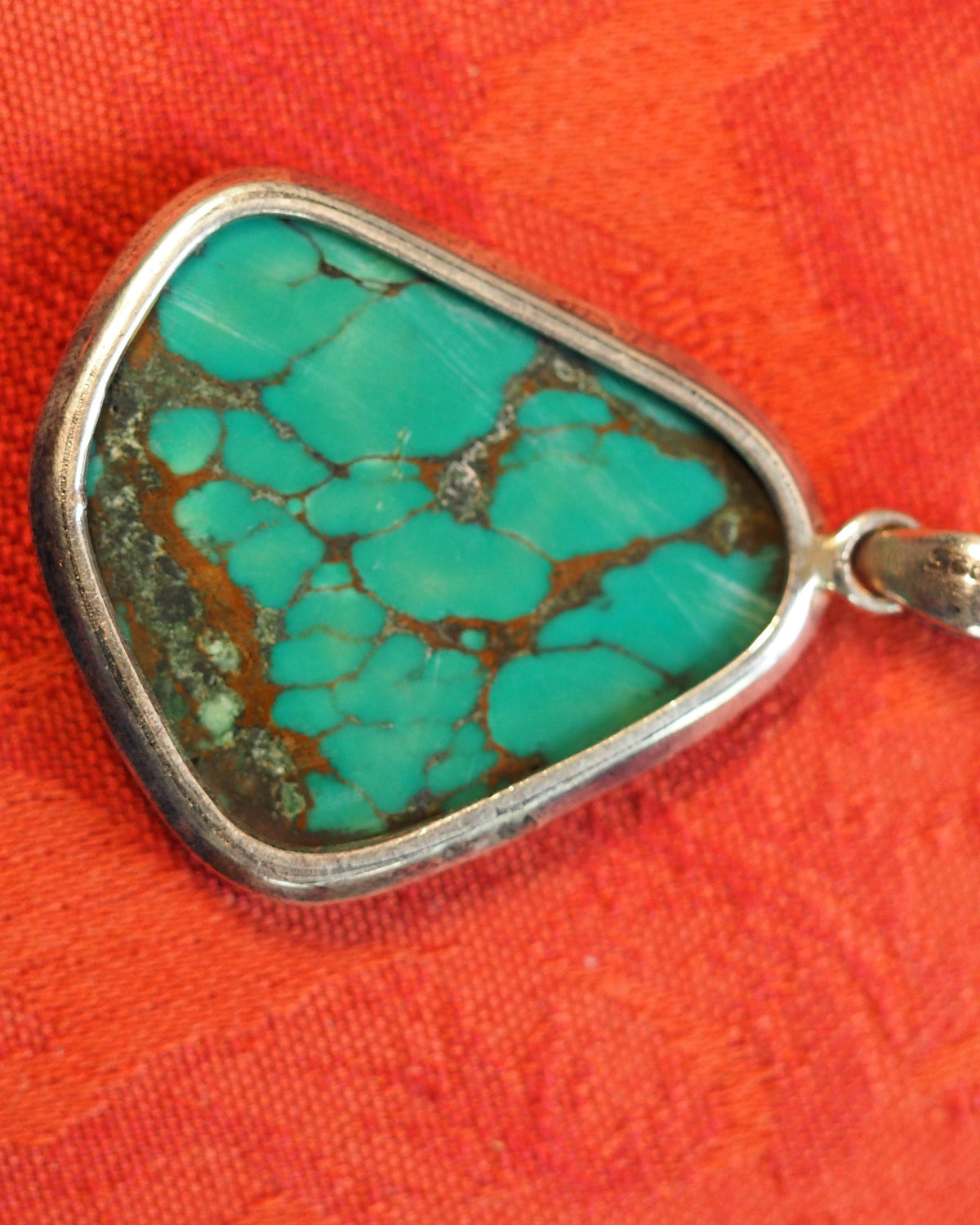 Sterling silver pendant back view, bezel edge and organic stone shape visible