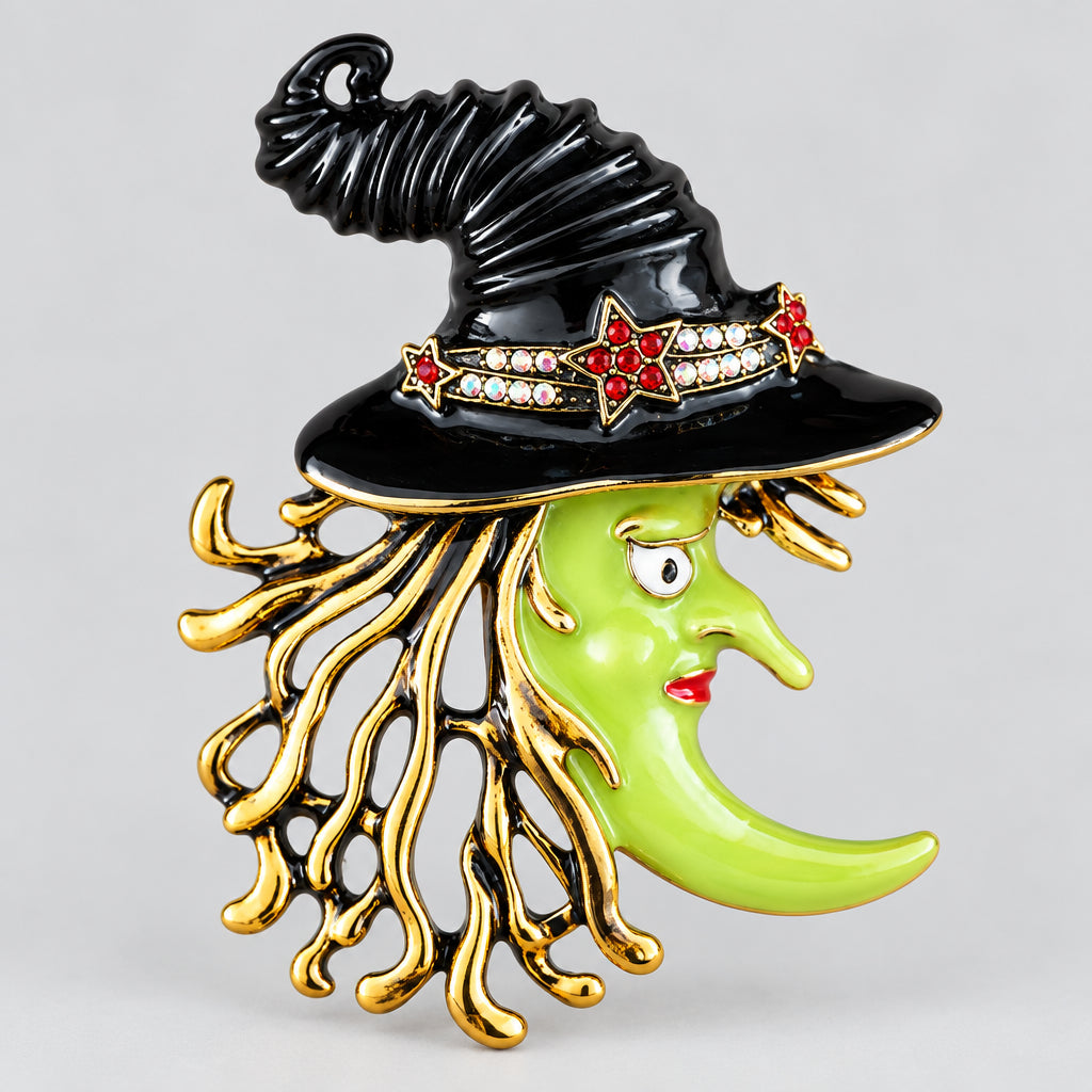 Vintage Kirks Folly witch brooch with green enamel face, black hat, rhinestones and gold-tone fringe, front view