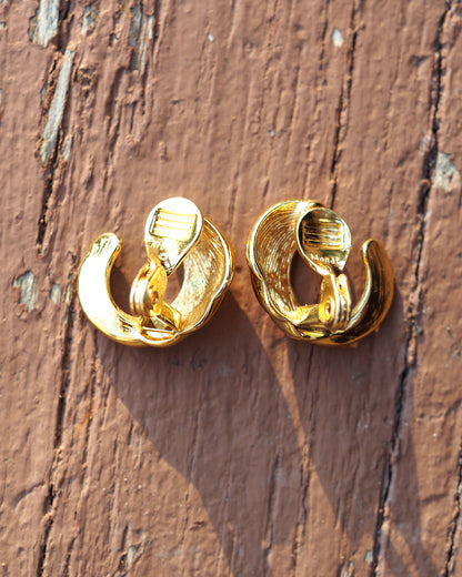 Reverse view of Monet clip earrings showing clip-on backs with ribbed comfort pads and signature stamp