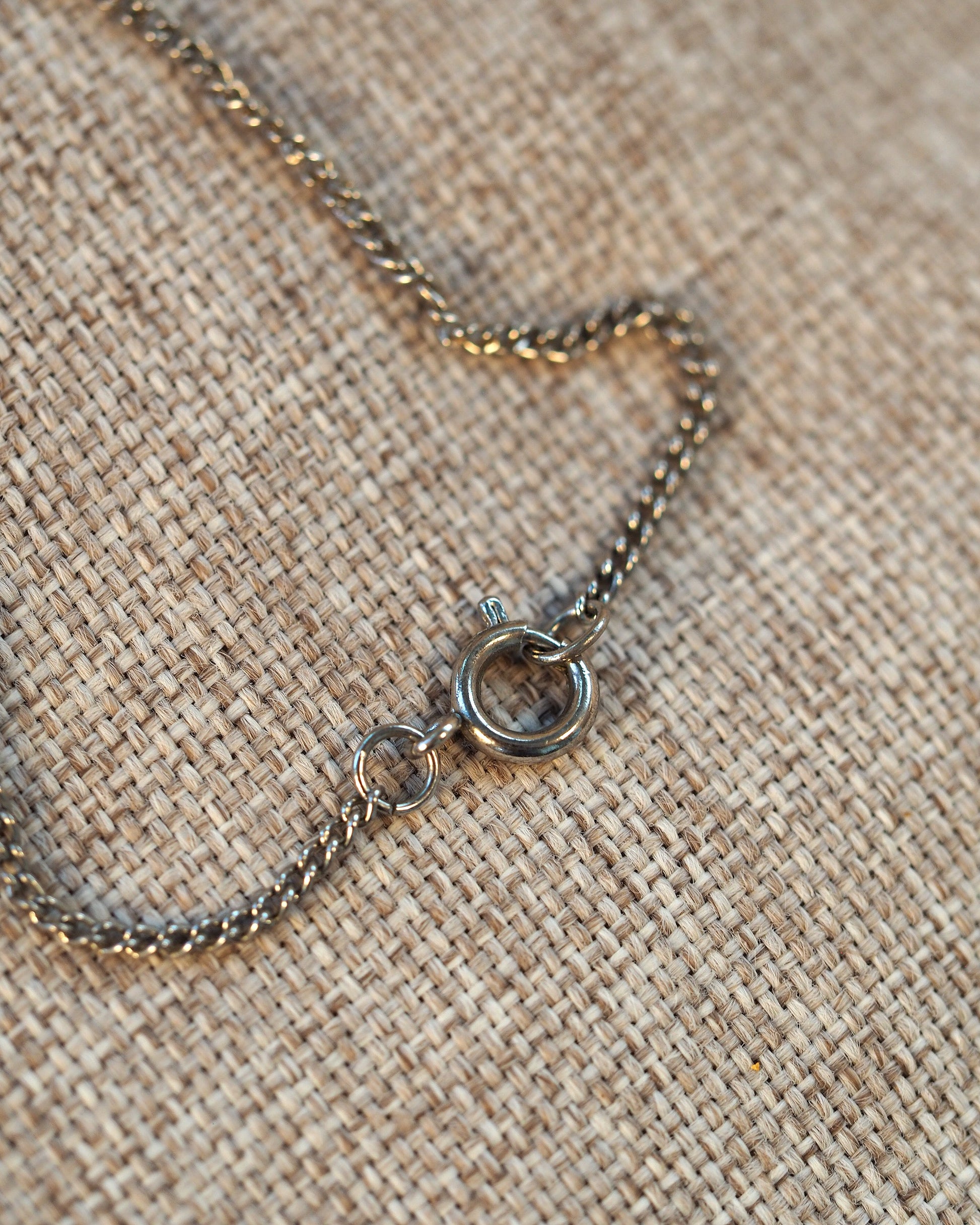 Gold-tone rose pendant shown in hand for scale, approximately 1.25 inches tall, displayed with 18-inch silver-tone chain
