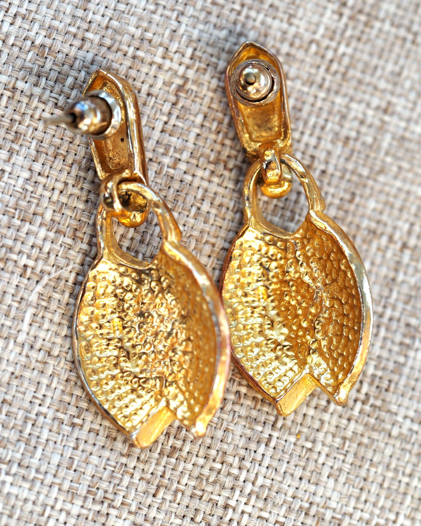 Back view of gold-tone leaf drop earrings showing textured reverse and articulated jump ring attachment