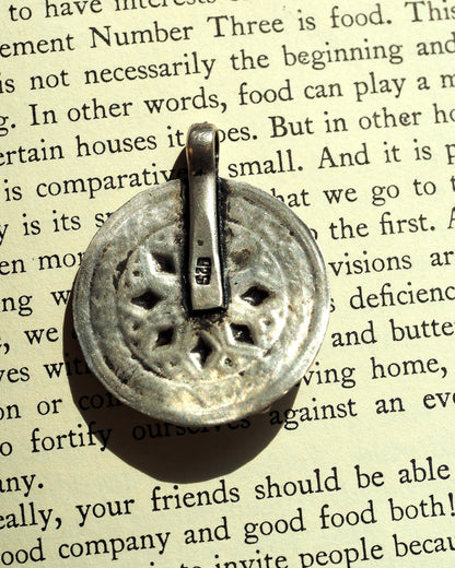 Back of sterling silver pendant showing pierced openwork and 925 hallmark on bail