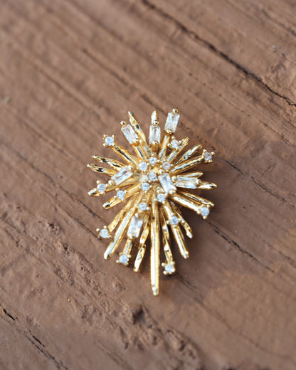 Single starburst earring front view, detail of alternating smooth gold rays and baguette/round rhinestone settings