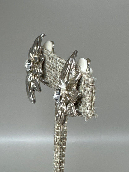 Side angle view showing dimensional layered leaf construction and sculpted depth of the clip earrings
