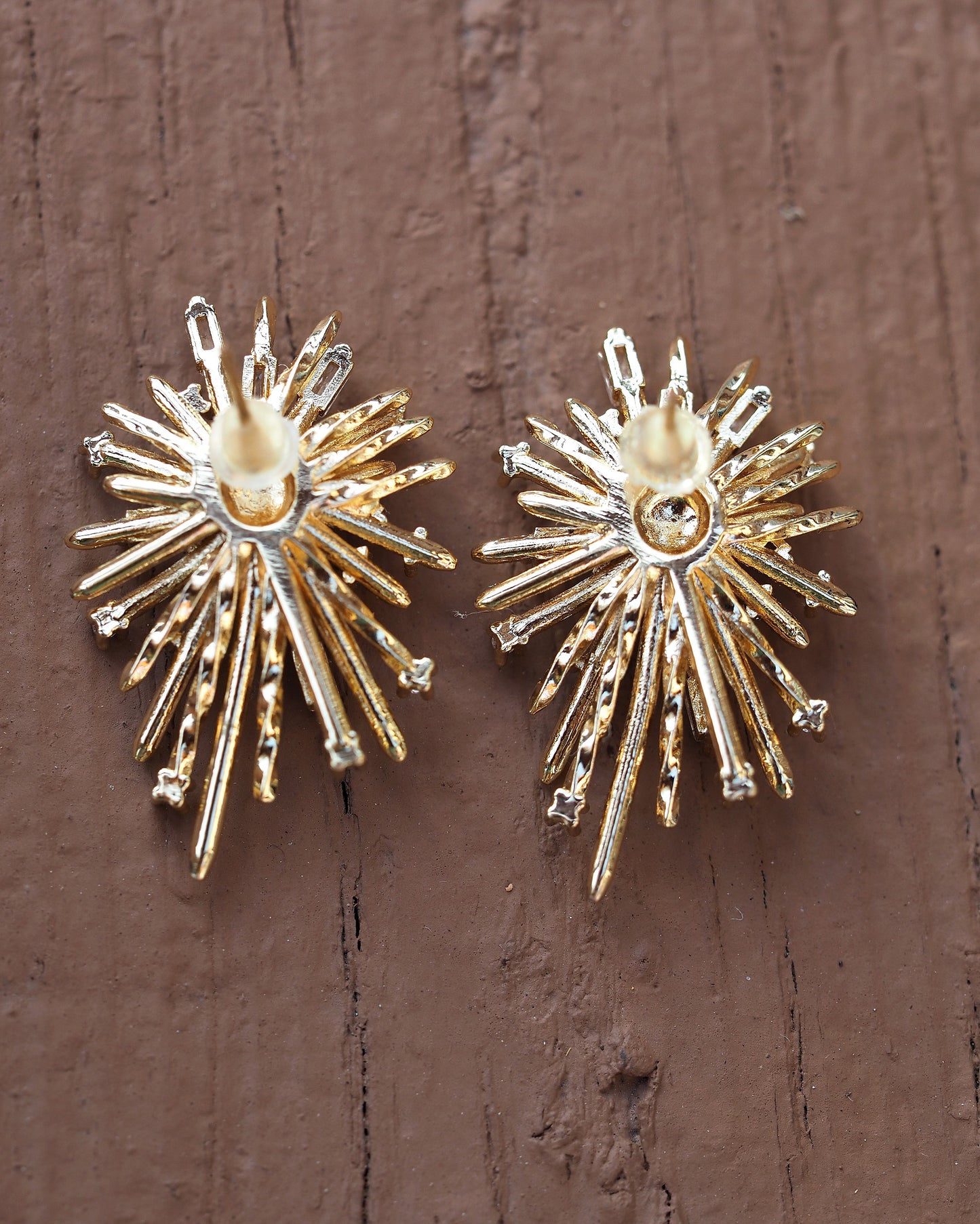 Pair of starburst earrings side-by-side on wood, showing scale and symmetry, approximately 1.25 inches tall