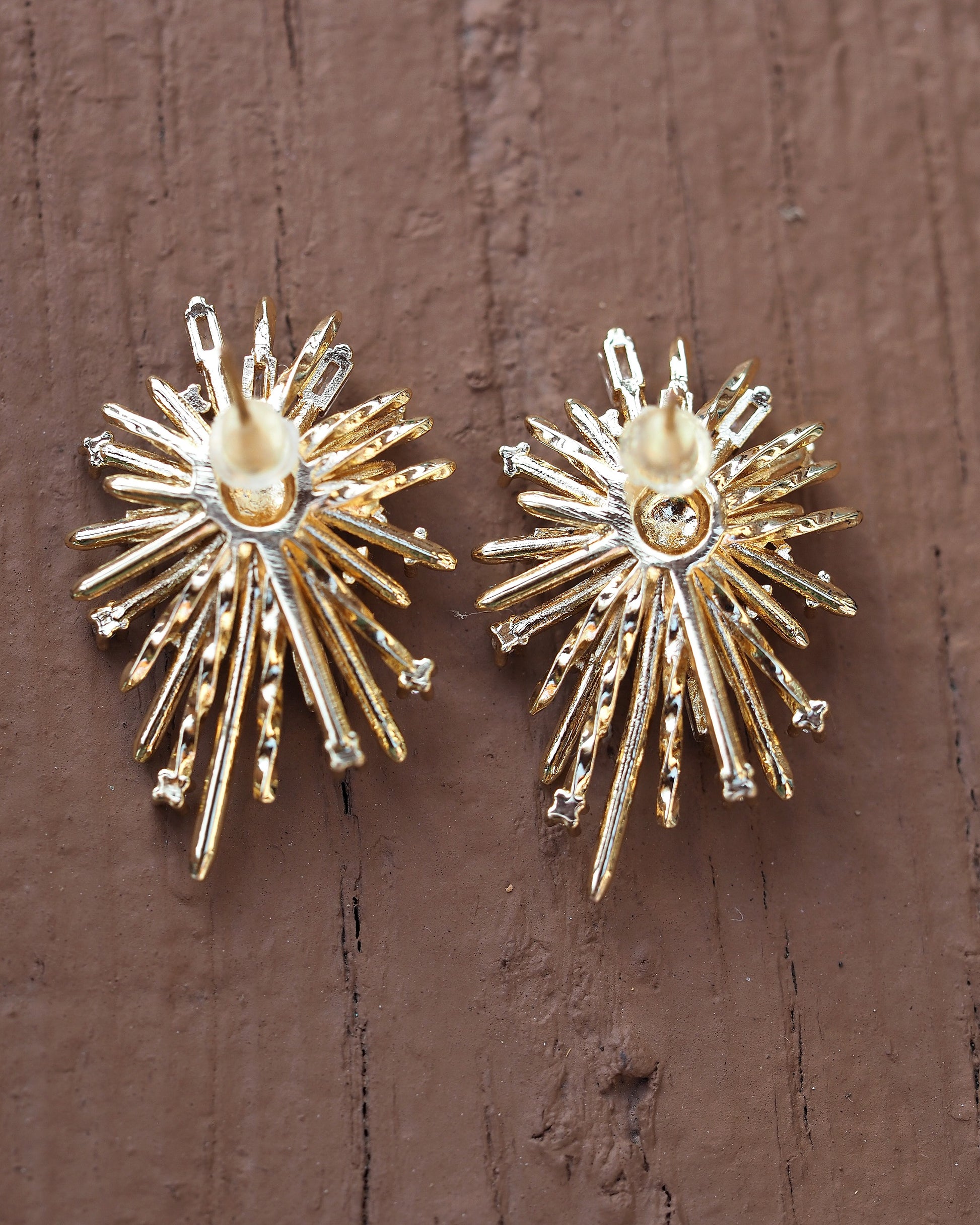 Pair of starburst earrings side-by-side on wood, showing scale and symmetry, approximately 1.25 inches tall