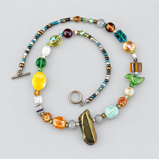 Colorful handmade glass bead necklace laid flat