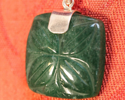 detail of the carved aventurine surface showing the symmetrical leaf or floral pattern and polished finish