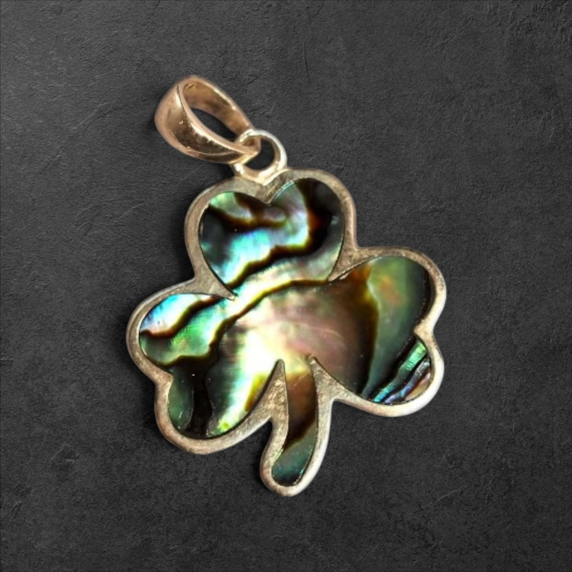 GlamGram NYC shamrock pendant featuring iridescent abalone shell inlay in a polished metal setting.