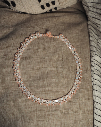 Full view of handmade beaded collar necklace on neutral linen, 17 inches around with button closure at top