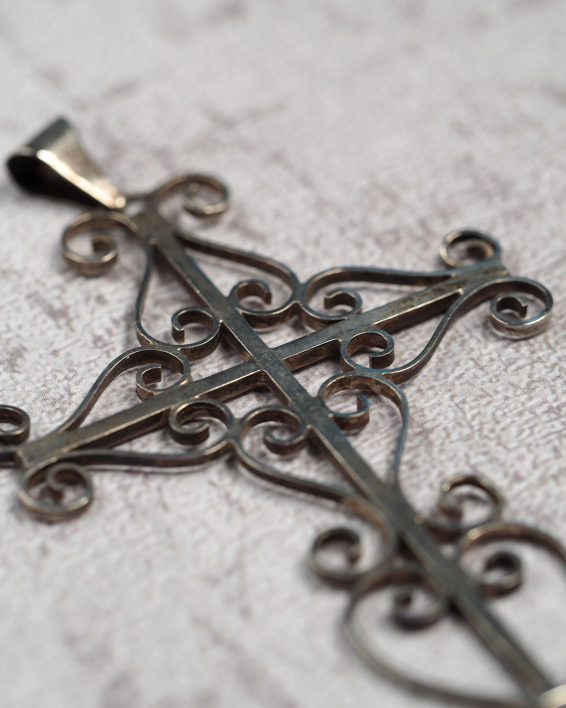 Three-quarter view showing the dimensional openwork cross and slide bail