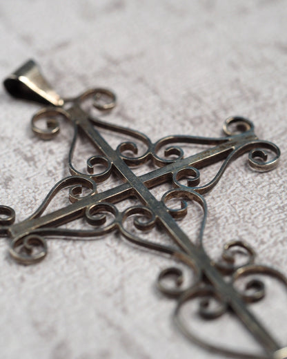 Three-quarter view showing the dimensional openwork cross and slide bail