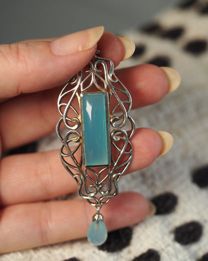 Derewala pendant held in hand for scale, showing 2.75 inch drop length