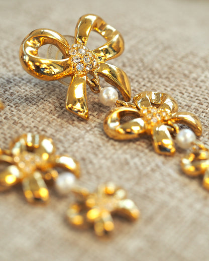 Reverse view of earrings on linen showing post backs and smooth gold-tone finish