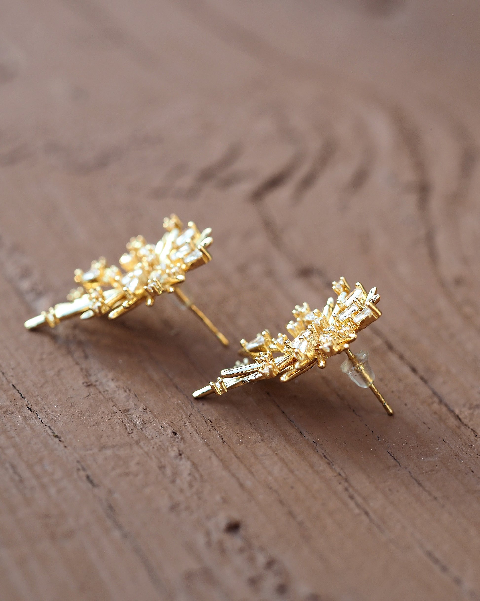 Close-up of post backs on gold plated sterling silver starburst earrings, showing central attachment and gold finish