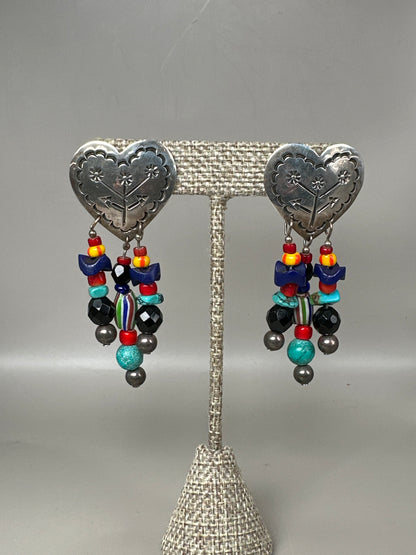 Sterling silver Taxco heart pierced earrings with turquoise-colored and glass beaded dangles, front view on stand