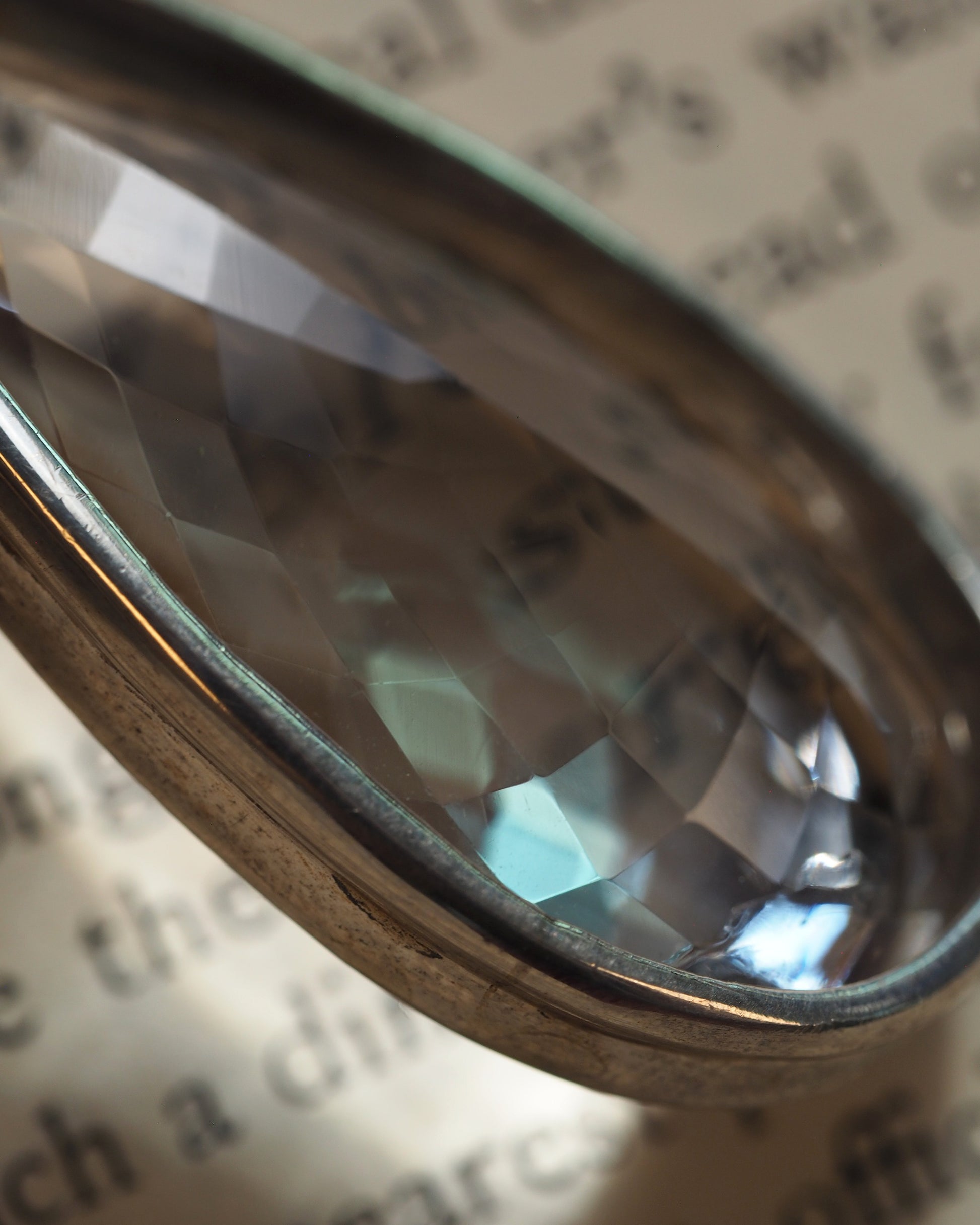 Close-up of the faceted clear stone showing crisp cut detail and bezel edge