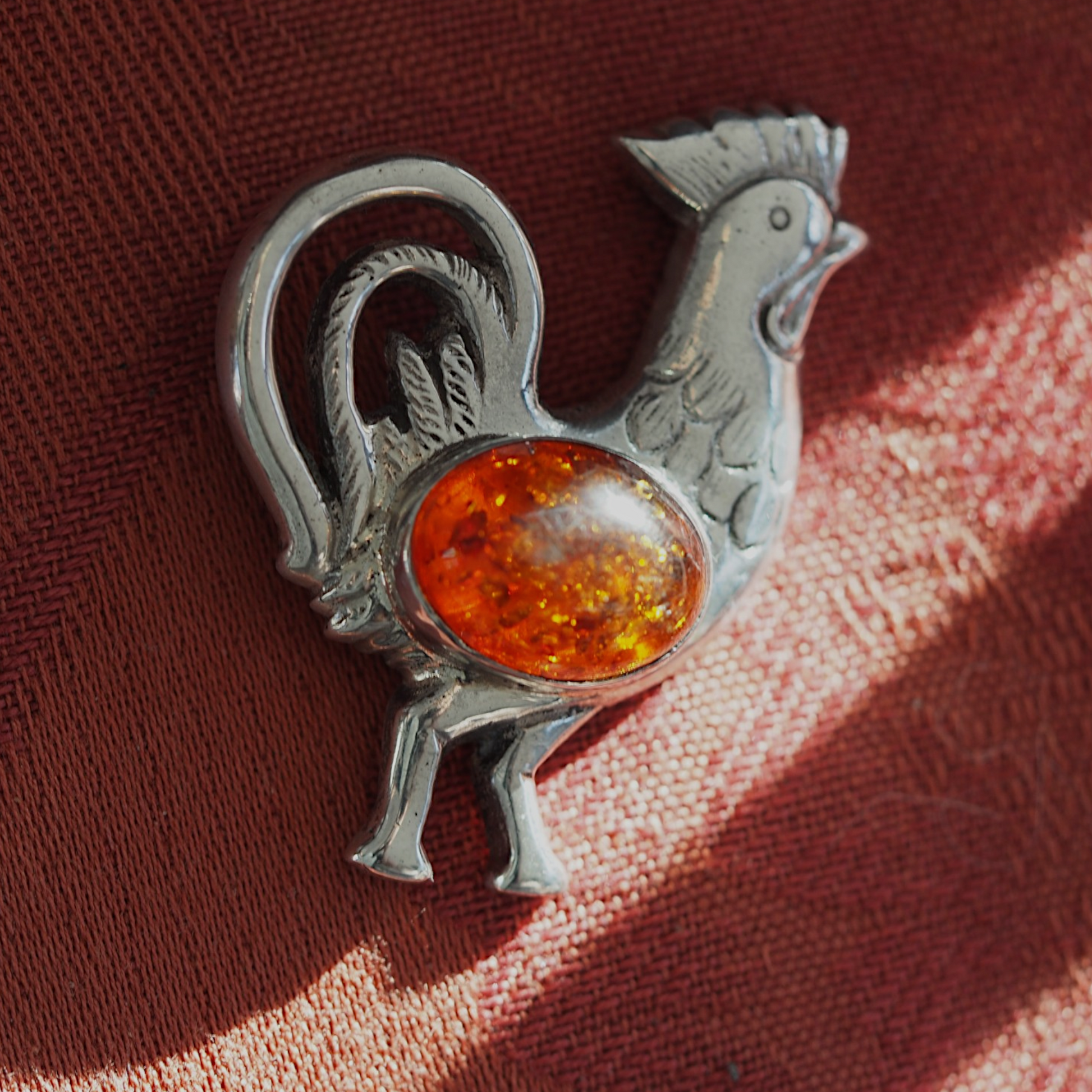 Amber rooster pendant glowing in natural light