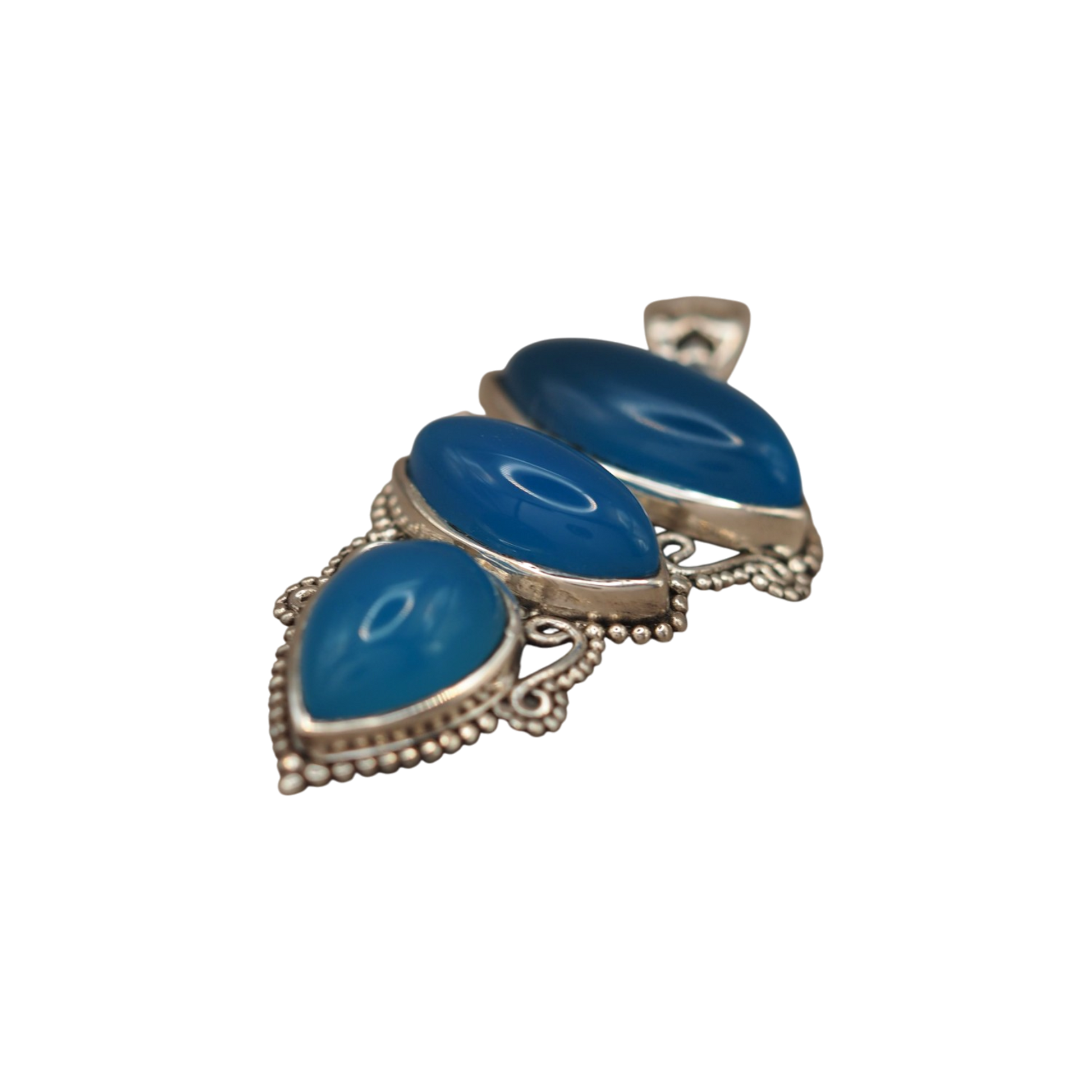 Angled view of blue chalcedony cabochons and ornate silver scrollwork