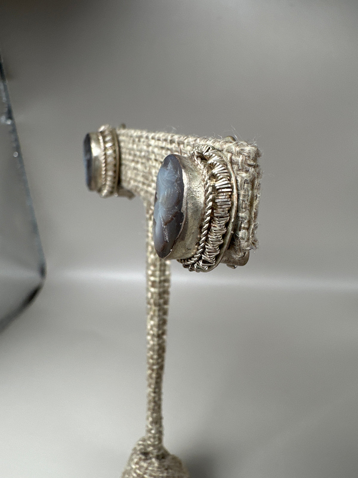 side angle showing hinged clip mechanism and bezel depth on one cameo earring