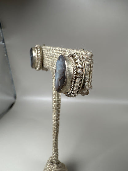 side angle showing hinged clip mechanism and bezel depth on one cameo earring