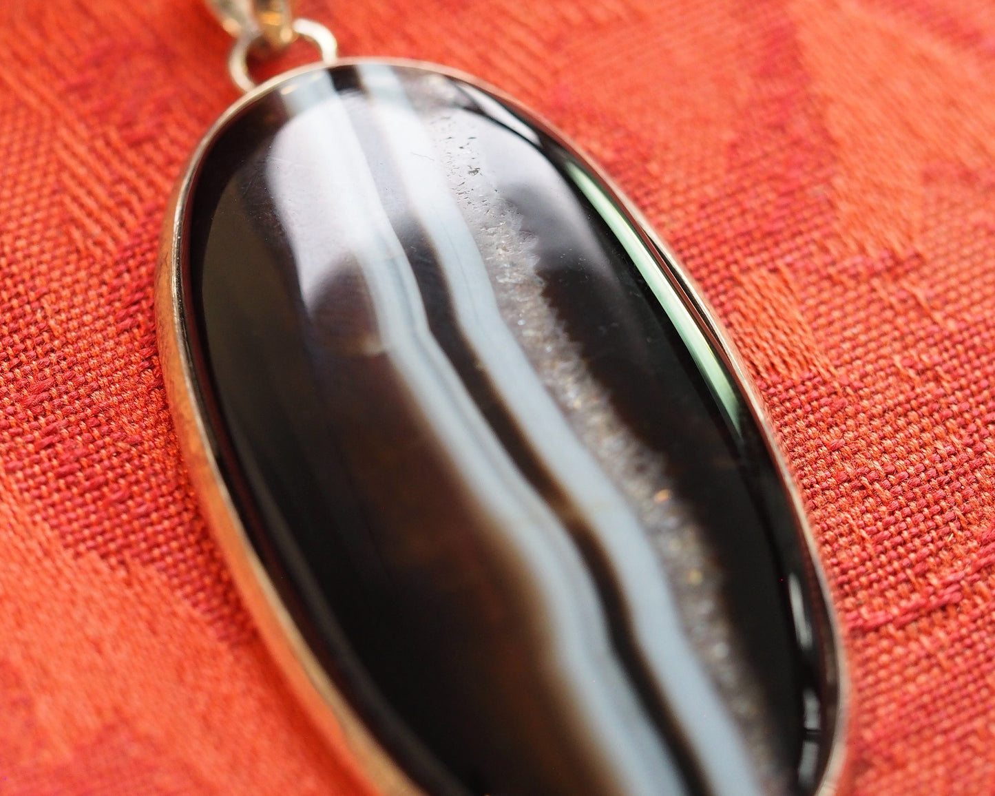 Close-up of banded agate surface showing polished striped pattern with visible depth at stripe edges