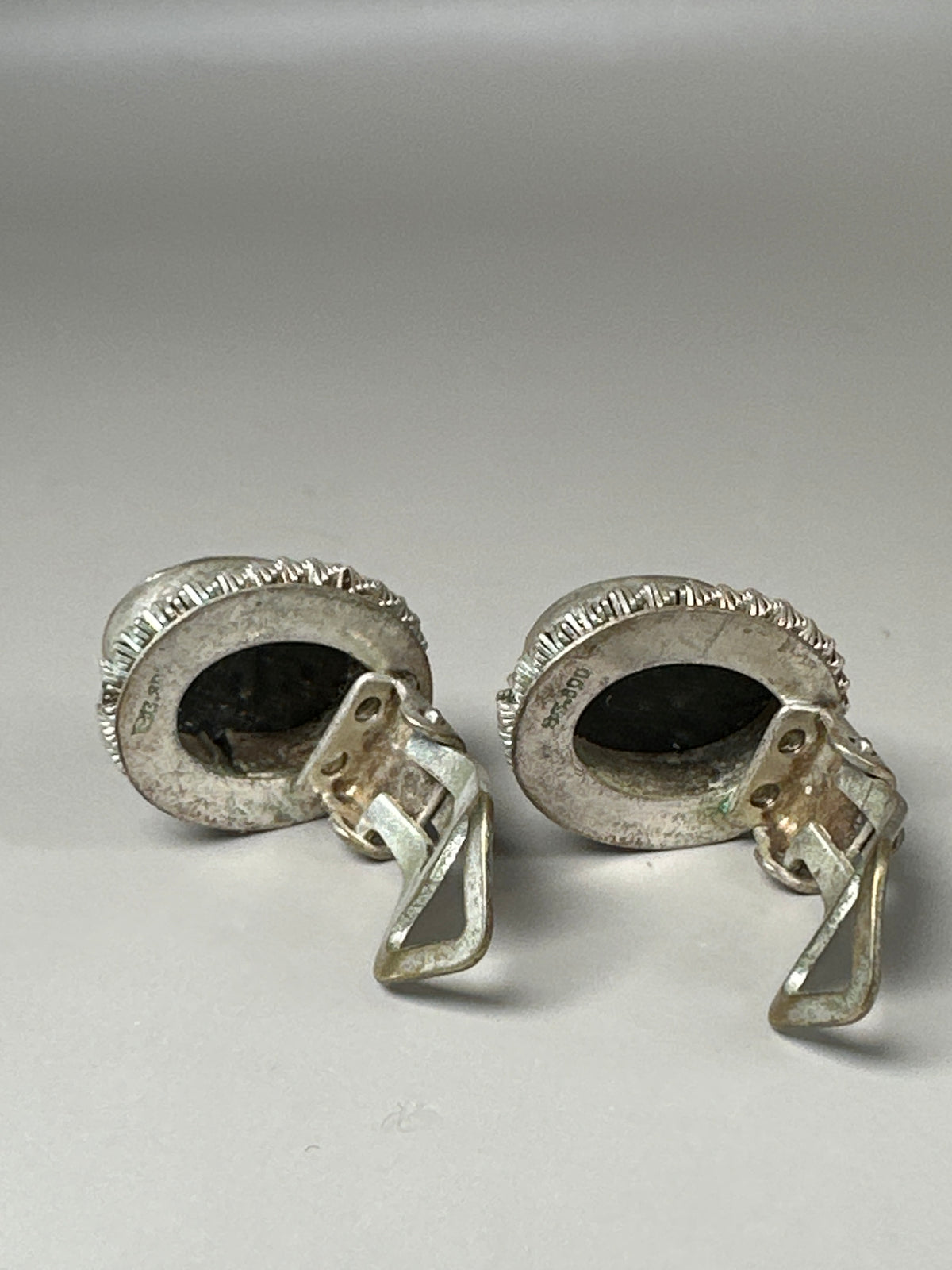 back view of both cameo earrings showing closed smooth backs and clip mechanisms