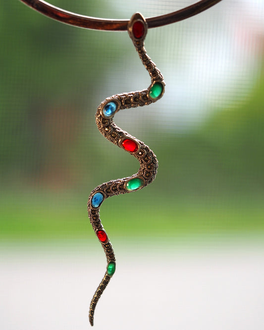 Sterling silver snake pendant with red, green, and blue cabochons in an S-curve, marcasite surface, front view against neutral background