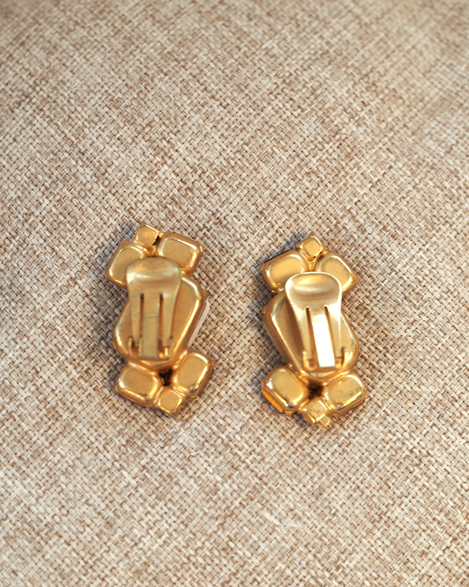 Reverse side of both earrings showing the gold-tone metal backs and clip-on closures