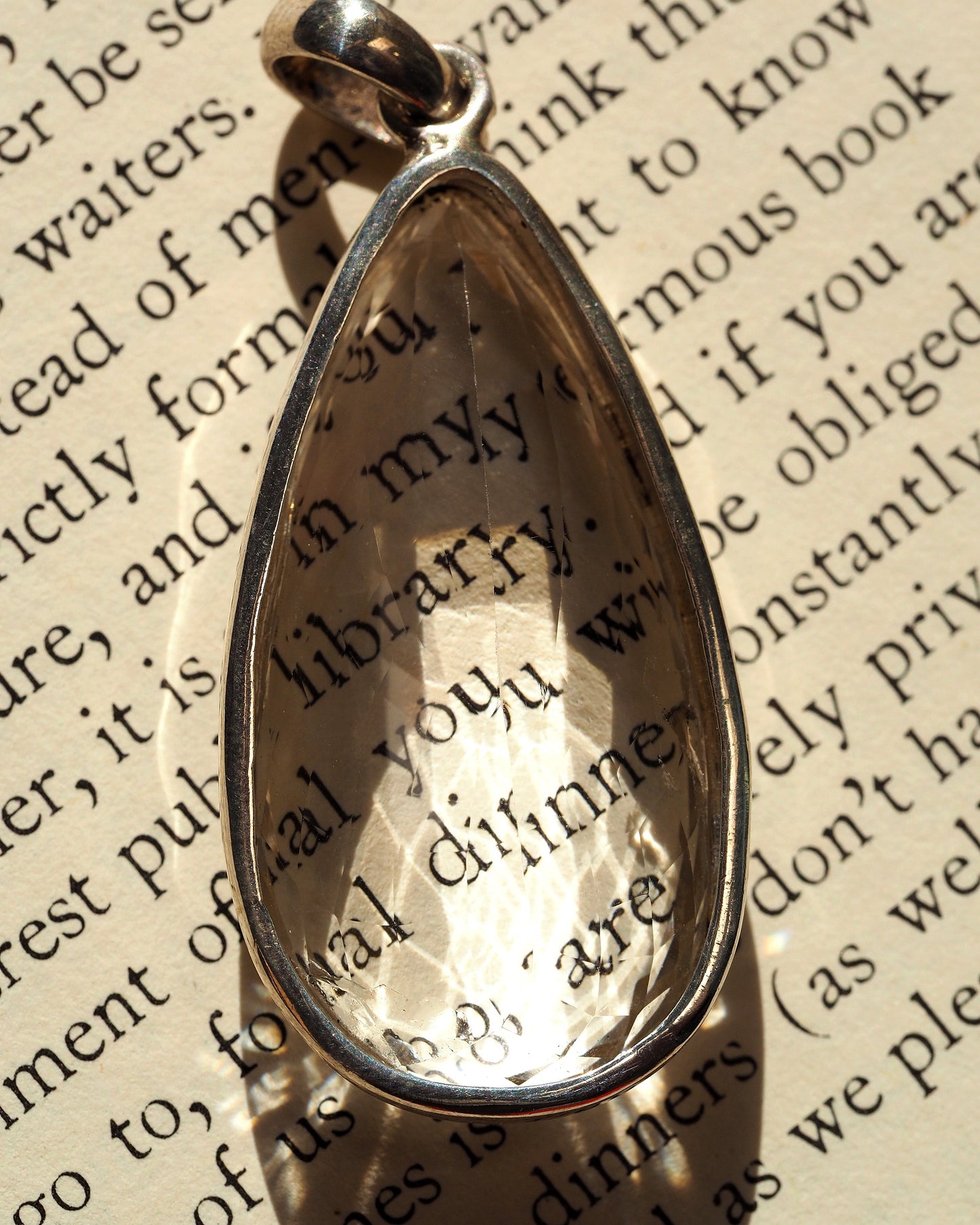 Back view of the sterling silver pendant showing smooth clear stone backing and slide bail