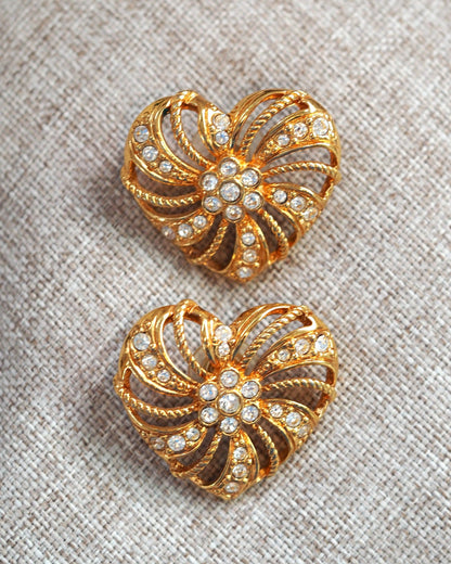 pair of 1980s heart-shaped pinwheel earrings on textured fabric, full front view