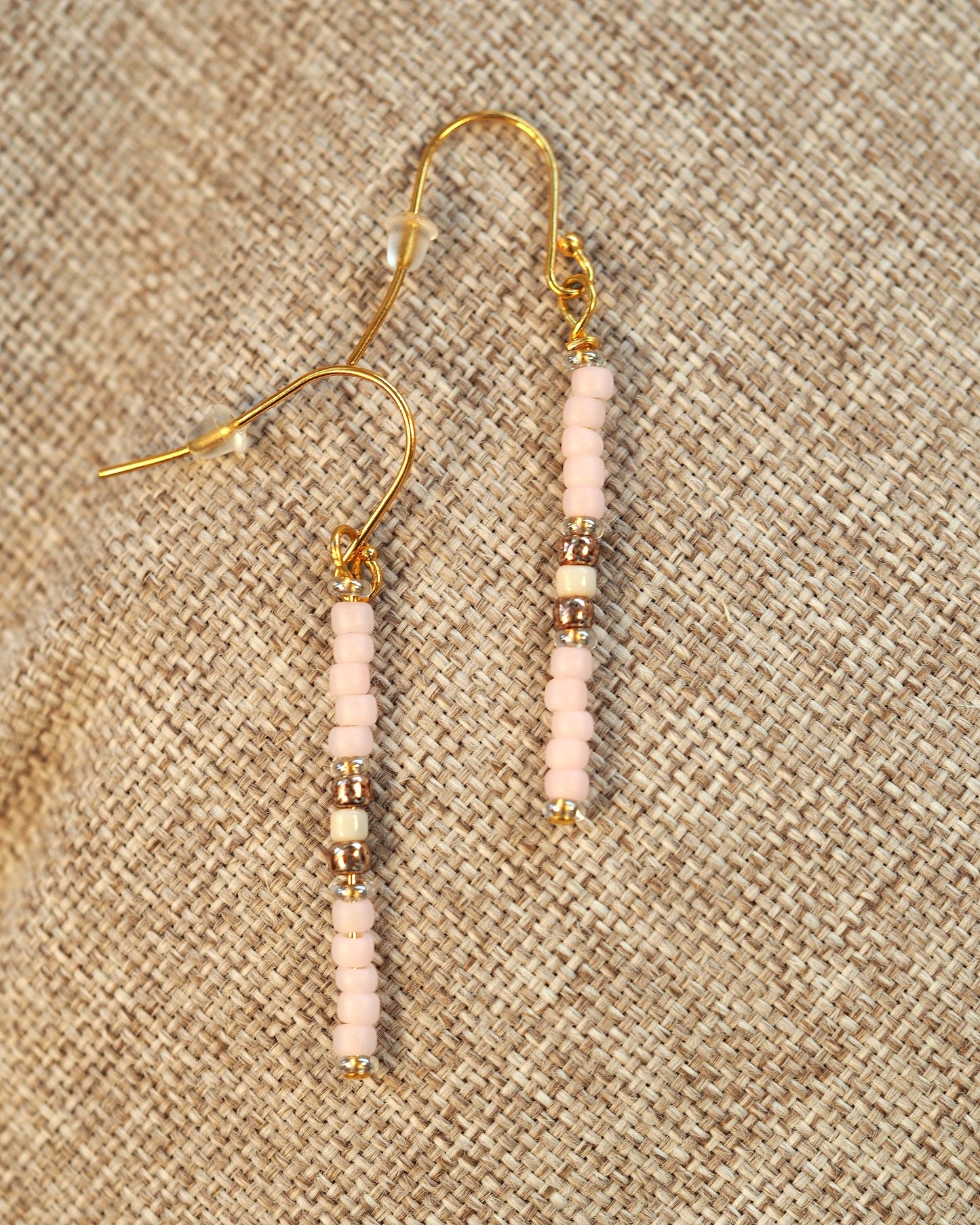 Back view of handmade pink glass bead drop earrings showing gold-tone fishhook ear wires and beaded construction