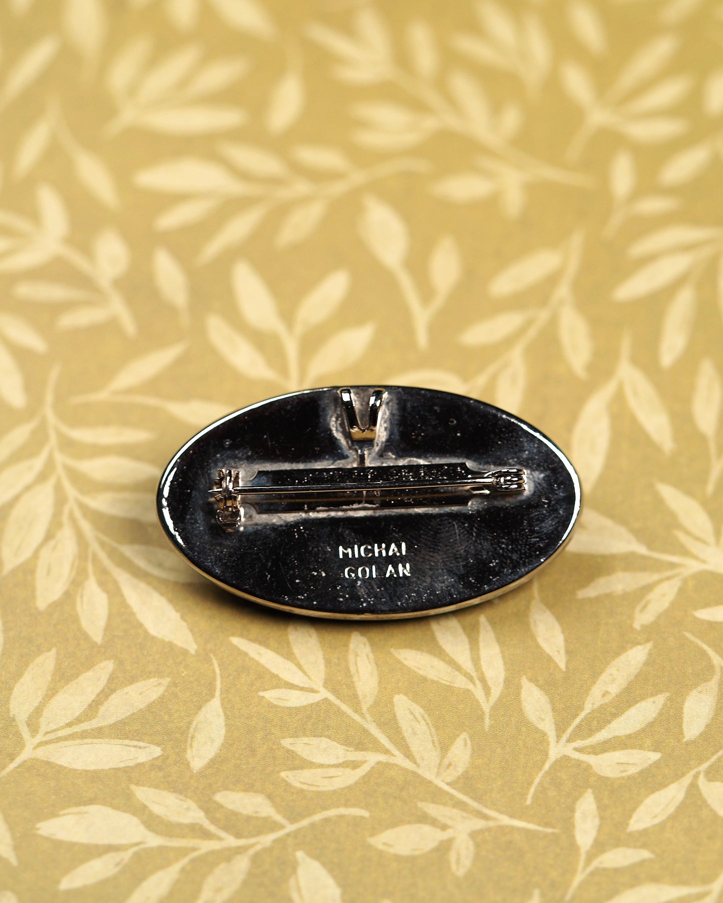Reverse of Michal Golan filigree brooch showing rollover pin clasp and signed back