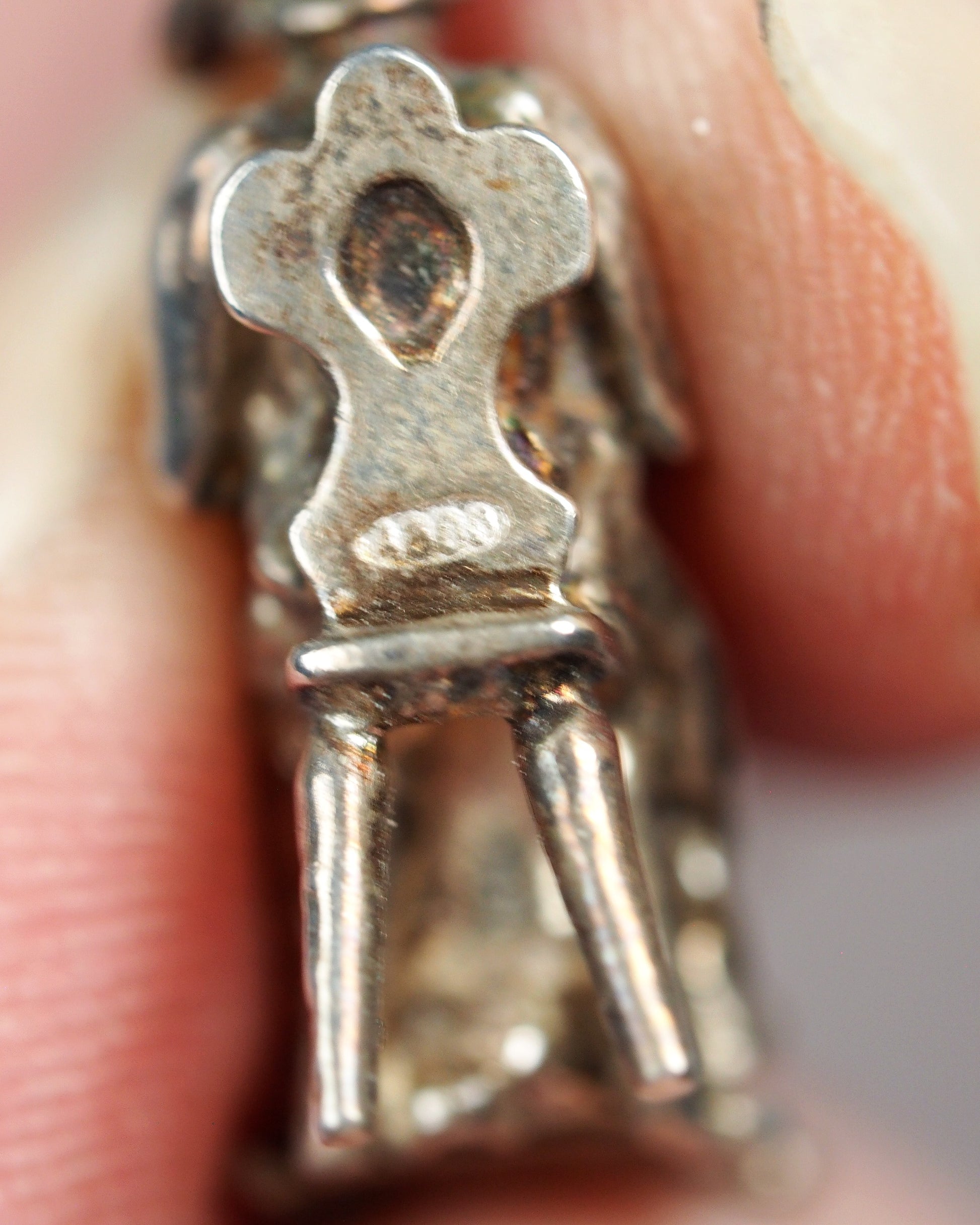lacemaker charm held between fingers for scale, showing three-quarter-inch height