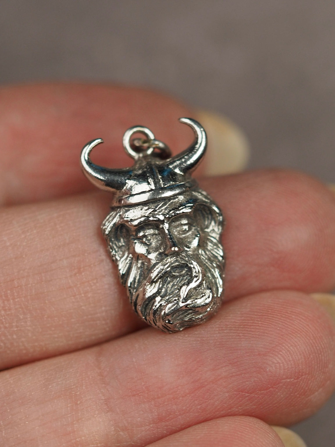 Vintage Kinney sterling silver Viking head charm pendant shown in hand