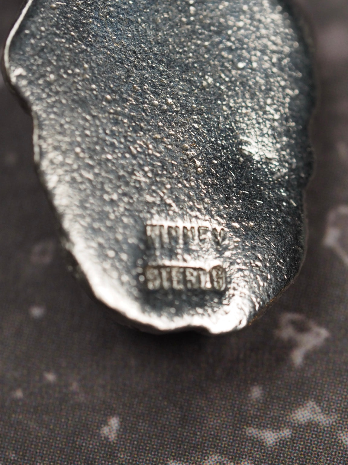 Back hallmark reading Kinney Sterling on vintage Viking head charm pendant