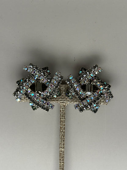 Clip earrings front view on stand showing symmetrical starburst design with AB crystals surrounding smoky centers