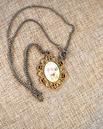 Close-up of silver-tone chain with spring ring clasp attached to gold-tone pendant bail
