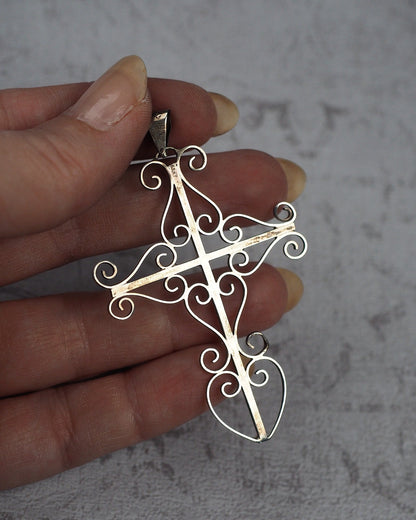 Large Taxco sterling silver cross pendant held in hand for scale