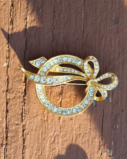 Nolan Miller brooch from a side angle showing the dimensional bow loops and ribbon tails with rhinestone detail